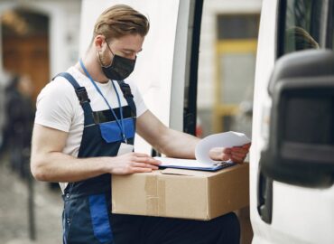 Courier delivery worker reviewing package documents before shipment